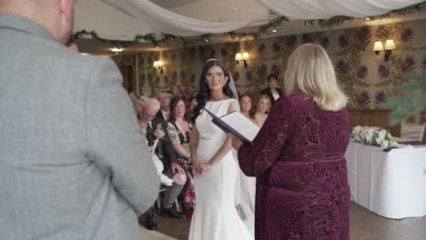 Wedding-registrar-performs-ceremony-watched-by-guests-and-happy-couple