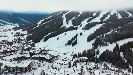 Foggy-cloud-layer-winter-snowy-early-morning-sunrise-aerial-drone-Copper-Mountain-Colorado-ski-resort-Eagle-Flyer-lift-center-village-half-pipe-Ikon-Epic-pass-snowboarding-forward-pan-reveal