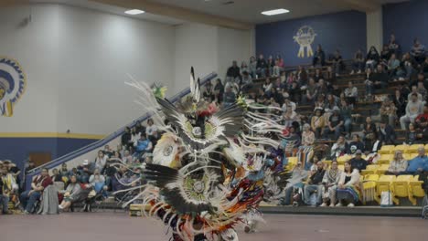 The-movements-of-Indigenous-dancers-adorned-in-elaborate-traditional-attire,-adorned-with-feathers,-beadwork,-and-vibrant-colors-at-Haskell-Indian-Nations-University's-Powwow-in-Lawrence,-KS