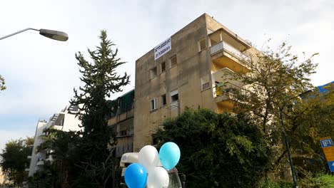 Abandoned-building-from-military-attacks-on-Israel,-rubber-balloons-in-the-foreground