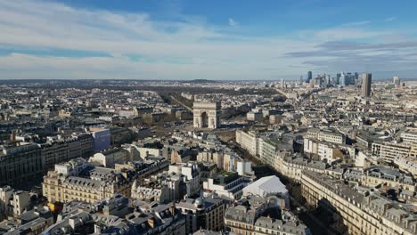 Triumphal-arch-or-Arc-de-Triomphe-with-Montparnasse-tower-and-La-Defense-skyscrapers-in-background,-Paris-urbanscape,-France