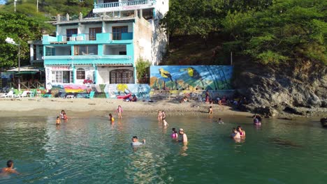 Seaside-sandy-shore-private-hotel-beach-South-America,-people-in-water