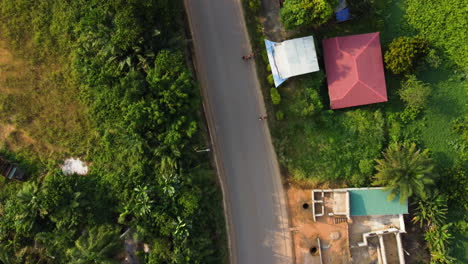 Drone-De-Arriba-Hacia-Abajo-Sobre-Una-Calle-En-La-Ciudad-De-Ebolowa,-Hora-Dorada-En-El-Sur-De-Camerún