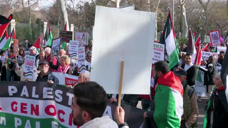 Protesters-hold-a-banner-and-wave-Palestine-flags-during-a-march-in-solidarity-for-Palestine