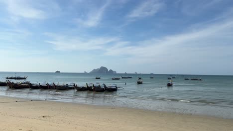 Empty-clean-beach-perfect-holiday-weather,-traditional-thai-long-tail-boats