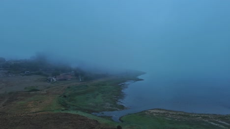 Twilight-haze-over-Nanclares-de-Gamboa-lakeside,-with-foggy-ambiance-and-serene-landscape,-Basque-Country