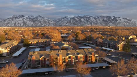 Volando-Sobre-La-Comunidad-De-Apartamentos-Sobre-Midvale-Utah-Al-Atardecer-Y-Una-Hermosa-Vista-Desde-Las-Montañas