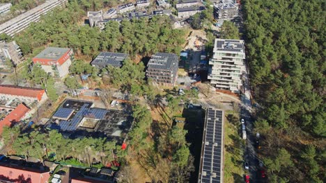 Stunning-aerial-of-city-block-with-apartment-buildings-surrounded-by-green-forest