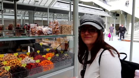 Mujer-Turista-Sonríe-Felizmente-Junto-A-La-Tienda-De-Nueces,-Mercado-De-Bolhao,-Porto