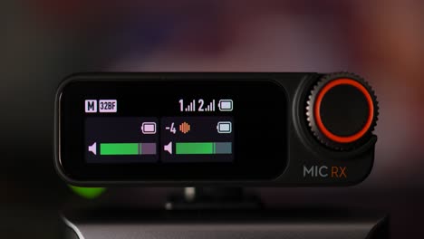 La-Pantalla-OLED-Dji-Mic-2-Rx-Del-Receptor-De-Micrófono-Inalámbrico-Muestra-Una-Variedad-De-íconos-Como-Volumen,-Nivel-De-Batería-Y-Frecuencia