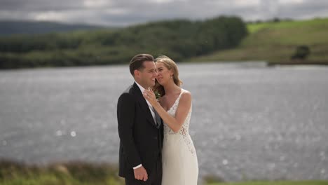 Serene-lake-background-newly-wedded-couple-seal-the-marriage-with-kiss