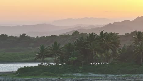 Luftparallaxe-Um-Tropische-Palmen-Auf-Der-Strandhalbinsel-Mit-Schillernd-Leuchtenden-Sonnenuntergangsstrahlen