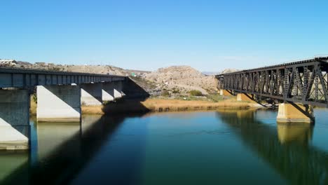 Flying-Low-Between-Two-Bridges,-Colorado-River-,-I-40-freeway-East,-Drone-Establishing