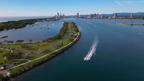 Reversing-aerial-views-over-the-Broadwater-and-The-Spit-following-a-jetski-on-the-Gold-Coast,-Australia