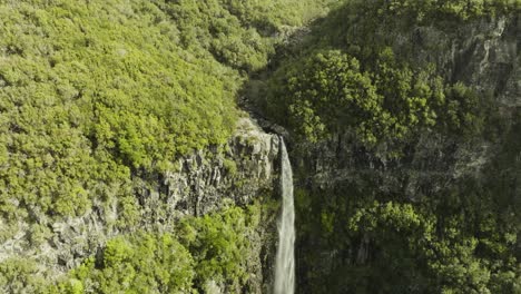 Drone-shot-moving-close-to-the-top-of-a-waterfall