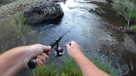 Toma-De-Punto-De-Vista-De-Un-Hombre-Pescando-Una-Trucha-Marrón-De-Un-Río-Australiano.