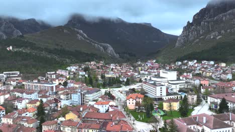 Drone-shot-of-a-small-village-next-to-a-mountain