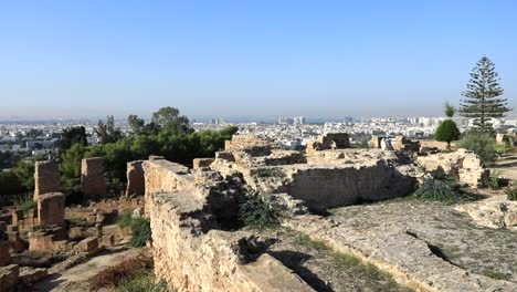 Ruins-of-ancient-Carthage-with-clear-sky,-overlooking-modern-city-in-Tunisia,-daytime