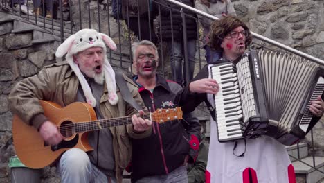 Musicians-in-costumes-play-live-during-the-Stilzer-Pgluagziachn-carnival-celebrations-in-Stilfs---Stelvio,-South-Tyrol,-Italy