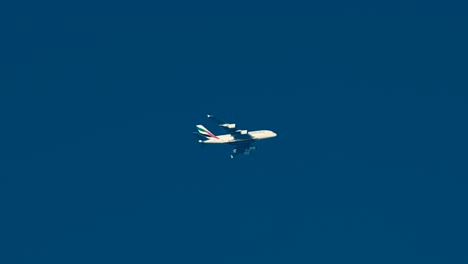 An-Emirates-Airline-Airbus-A380-flying-high-in-the-blue-sky-over-Dubai,-United-Arab-Emirates