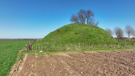 Flying-Towards-The-Tumulus,-Burial-Mound-In-The-Countryside