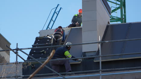 Technicians-installing-solar-panels-on-residential-house-roof