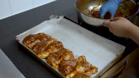 Marinating-chicken-for-baking,-with-hand-brushing-sauce-on-meat,-kitchen-setting