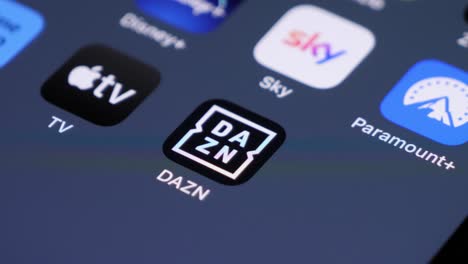 Primer-Plano-Del-Usuario-Deslizando-El-Dedo-En-Un-Teléfono-Inteligente,-El-ícono-De-La-Aplicación-Dazn-Enfocado,-Entre-Otros