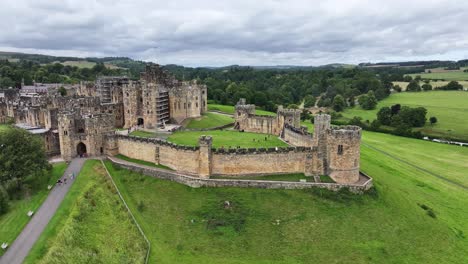 Drone-Shot-of-Alnwick-Castle,-Medieval-Landmark-and-Landscape-of-Northumberland,-England-UK-60fps