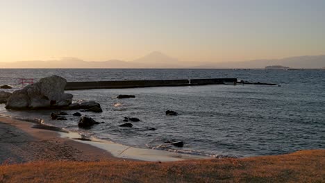 Amplia-Playa-Abierta-Al-Atardecer-Con-Silueta-De-Mt.