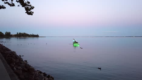 Romantic-couples-exploring-the-Lake-Balaton-with-illuminated-pedal-boats-during-dusk-at-Balatonfüred,-Hungary