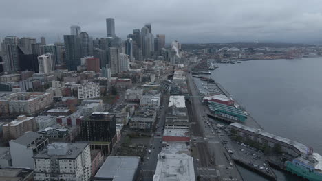 Toma-Aérea-Del-Muelle-De-Seattle-Y-Del-Horizonte-Del-Centro-De-La-Ciudad-Panorámica-Hacia-La-Derecha