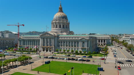 Sunlit-San-Francisco-City-Hall-with-clear-blue-skies,-vibrant-cityscape-view,-flags-fluttering