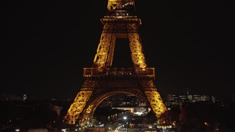 Two-Lower-Floors-of-Eiffel-Tower-at-Night-with-Traffic-in-Paris