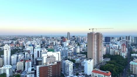 Aerial-establishing-shot-of-Santo-Domingo-City-at-sunset