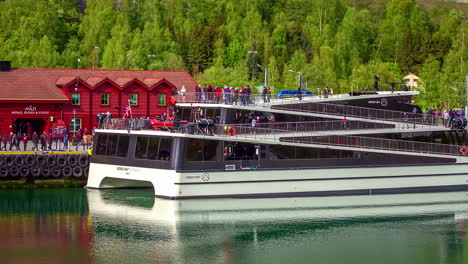 People-boarding-modern-catamaran-timelapse,-boat-departs-from-Flam,-Aurland,-Norway