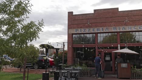 Pizzeria-Bianco-restaurant-outside-with-people-in-front-located-in-Phoenix,-Arizona-with-video-panning-left-to-right