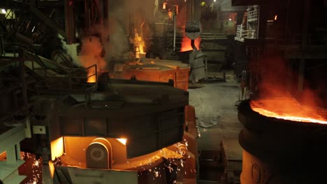 Glowing-furnace-at-a-foundry-with-molten-metal-and-flying-sparks,-industrial-setting