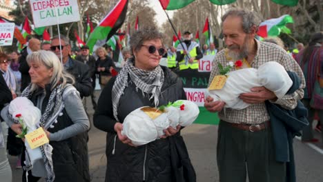 Protesters-hold-cloth-bundles-depicting-a-dead-baby-during-a-march-in-solidarity-for-Palestine