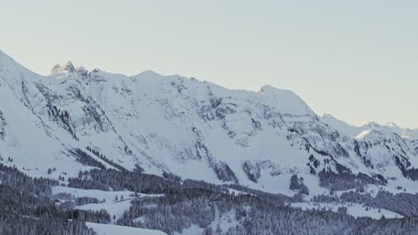 Silhouette-of-a-snowy-mountain-range-captured-from-above-during-sunrise