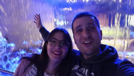 Fröhliches-Paar-Macht-Ein-Selfie-Bei-Der-Wasserfallausstellung-Im-Guinness-Storehouse