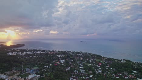 Luftaufnahme-Von-Lebhaften,-Wolkigen-Sonnenuntergangsstrahlen-An-Der-Küste-Von-Las-Terrenas