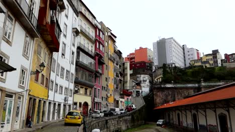 Colorful-buildings-line-a-steep-street-in-Porto,-overcast-sky-above