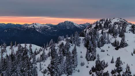 Malerische-Schneebedeckte-Berg--Und-Baumlandschaft,-Farbenfroher-Sonnenuntergangshimmel