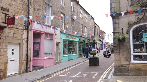 Local-Shops-and-People-in-Narrow-Pedestrian-Street-in-Downtown-Alnwick,-England-UK,-Slow-Motion