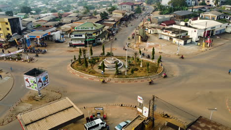 Traffic-at-the-Tamzou-Roundabout,-sunset-in-Ebolowa,-Cameroon---Aerial-view