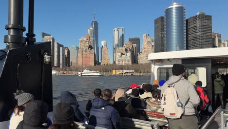 Personas-Sentadas-En-El-Ferry-Acercándose-Al-Centro-De-Manhattan,-Nueva-York