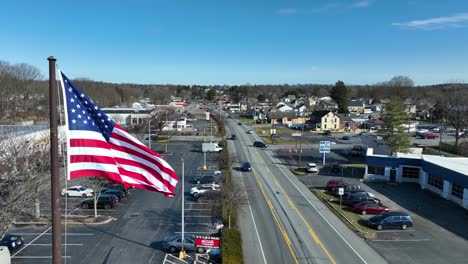 Amerikanische-Flagge-Weht-An-Einem-Sonnigen-Tag-Auf-Der-Hauptstraße-In-Einer-Amerikanischen-Stadt
