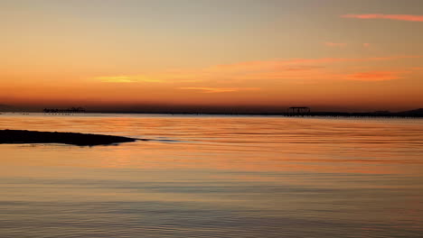 Vivid-sunset-reflected-into-the-ocean,-colorful-vibrant-skyline-at-dusk