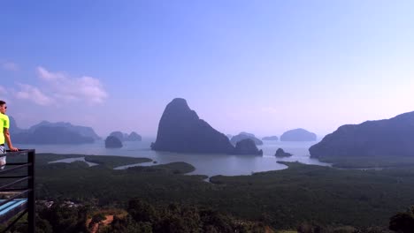 Cinematic-footage-in-4K-captures-a-man-gazing-out-at-the-picturesque-scenery-of-Panga-Bay-in-Thailand